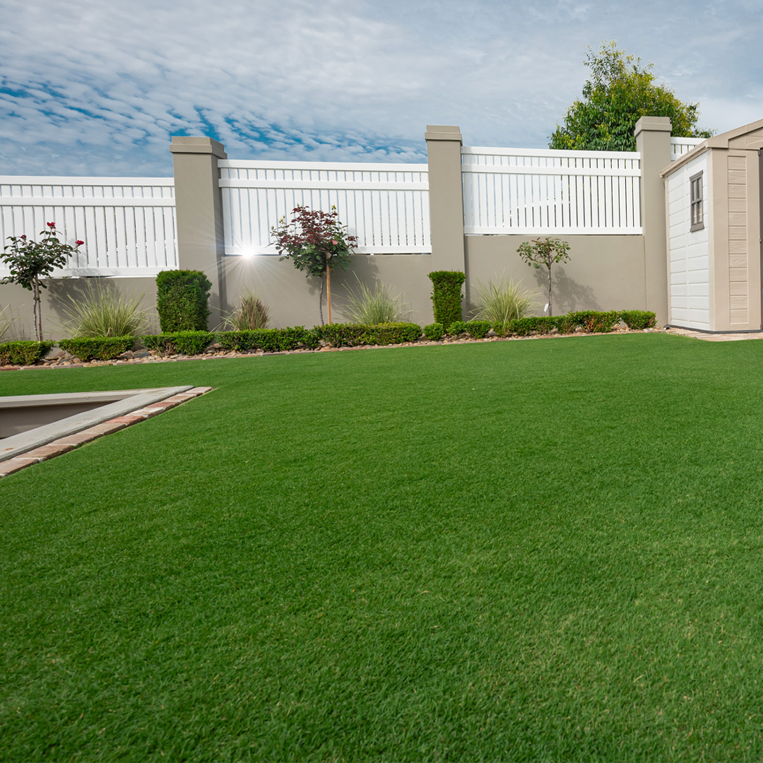 A white fence surrounding a lush area of TifTuf Bermuda grass