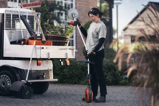 Woman holding a Husqvarna 525iLK Combi-Trimmer