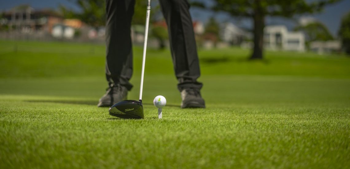 A person playing golf on a field installed with turf